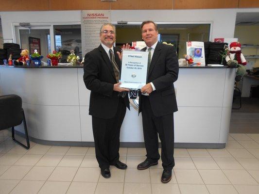 Dealer Principal Bill O'Neil receiving an award for 30 years in business with Nissan.