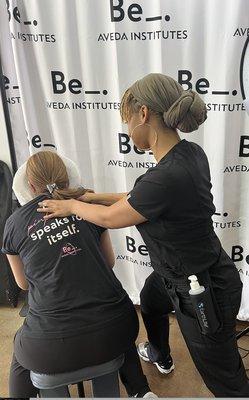 Lina give a chair massage at an Aveda Institute