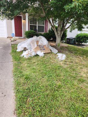 mover left all the trash taken from inside the house on the front lawn and drove away.