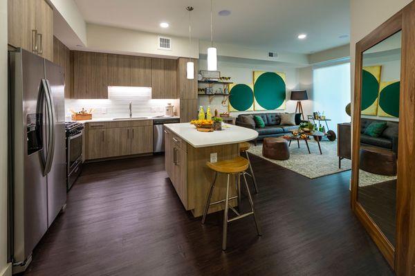 View of kitchen with island and living room in model