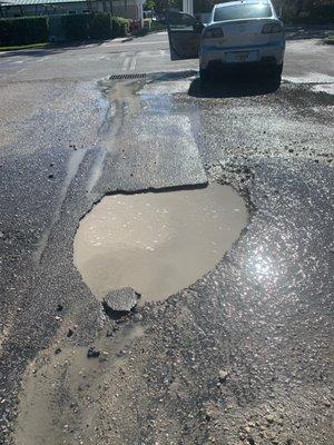 Deep Holes in side parking lot, that'll ruin your wheels or tie rods - waiting for property owner to call -