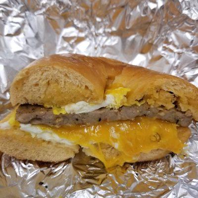 Double Cheddar Bagel Breakfast Sammie (cheddar bagel, cheddar cheese, sausage, & fried egg.)