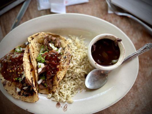 Carne asada corn tortillas tacos with rice and black beans.