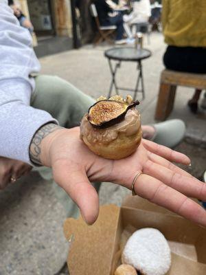 Very tiny and mediocre donut with half a fig on it.