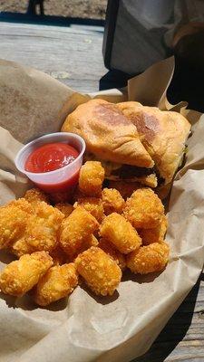 Green chile cheese burger on Jalapeño Cheddar sourdough with a side of tater tots