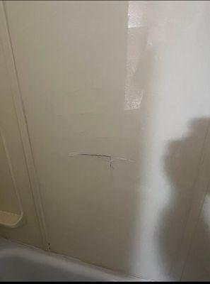 Cracks and caulking in the shower walls could possibly cut you or your children also appears to have bacteria growing behind it