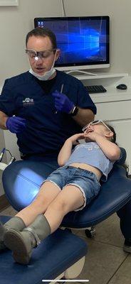 a smiling kid in a dentist chair