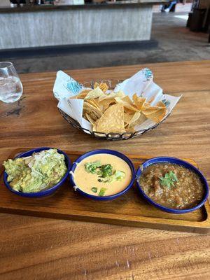 Mexican trifecta. Basically chips and salsa with guac queso and a roasted type salsa.