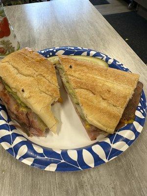 Cuban sandwich with Mojo pork, cheddar cheese, and pickles.