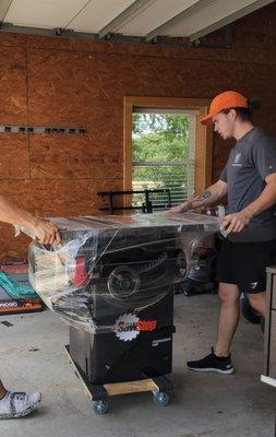 Movers moving woodworking equipment into a new shop!