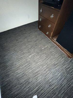 Carpet is coming apart and the dresser towards the bottom is all scratched up