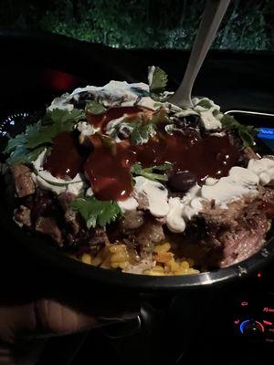 Brisket Bowl (yellow rice, brisket, black beans, cilantro, sour cream, spicy, and sweet bbq sauce on top).