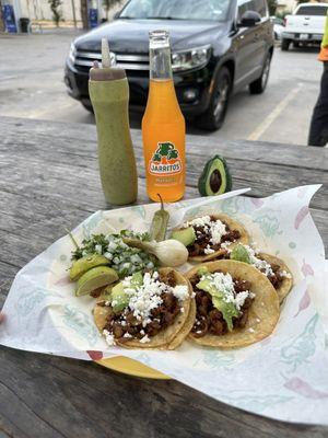 Mini plate of tacos al pastor and a Jarritos soda.