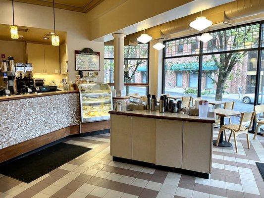 End of the counter, coffee station in the middle of the shop and some indoor seating