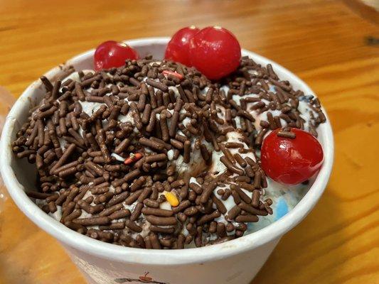 Birthday cake ice cream with cherries and chocolate sprinkles.