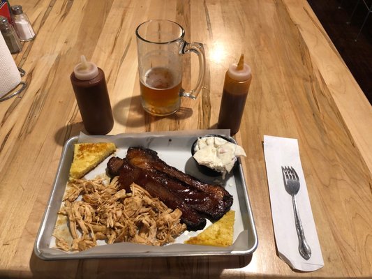 Two meat combo with cornbread pulled chicken brisket potato salad sweet sauce and vinaigrette sauce