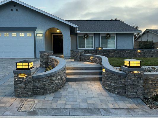 New interlock pavers plus chemical finish concrete surrounding the pavers.  New outdoor lighting and low maintenance front yard.