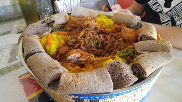 Messob.  A family shared meal with lamb, beef, chicken, lentils and other veggies. Nicely spiced.