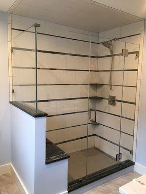 Frameless shower with double step up notched panel