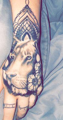 Hand tattoo of a lioness done by Cory Clark