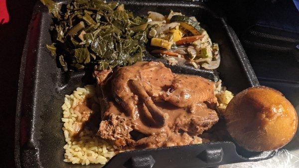 Baked chicken with rice and gravy, mixed vegetables, and collard greens.