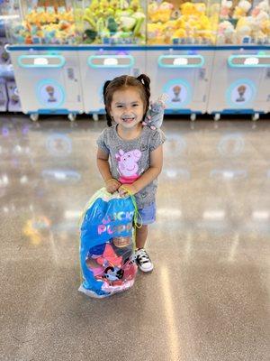 Cute little girl with her plushie bag full of prize winnings!