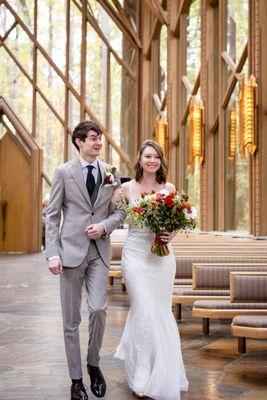 Joyful bride and groom walking down the aisle at Anthony Chapel in Hot Springs, Arkansas. Photo by Michele McCoy Photography