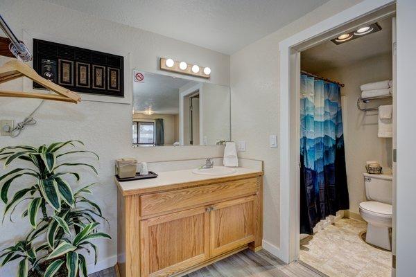 Large countertops and bright lighting in the bathroom spaces