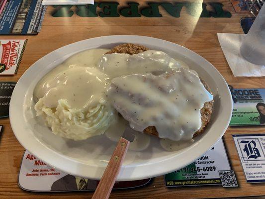 Country fried steaks 2 with mashed potatoes and gravy.