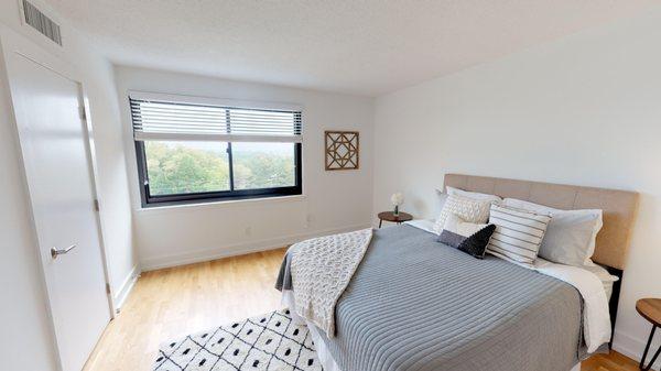 Bedroom with lots of natural light, hardwood floors and a large closet