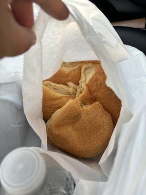 Fresh out of the oven pandesal in a white paper bag. They put a new plastic bag inside for you to put it in once it cools down.