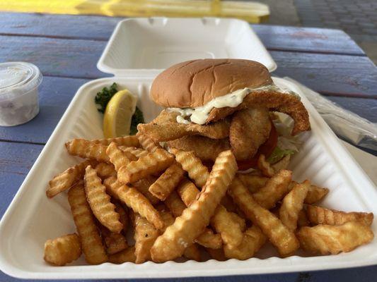 The flounder sandwich with a huge amount of fries.