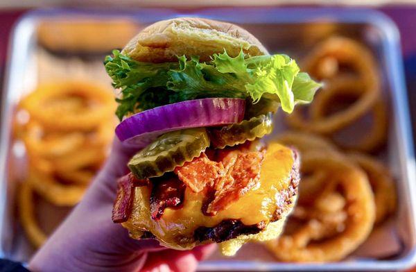 Heaven's bacon cheddar burger with a side of onion rings