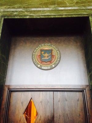 Seal of the university above the main reading room doors. Arts, Science, Truth.