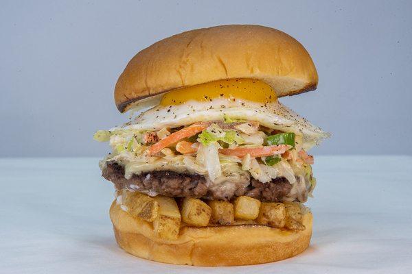 Slaw Burger impossible patty, white american cheese, fries, haus slaw, fried egg, mayo