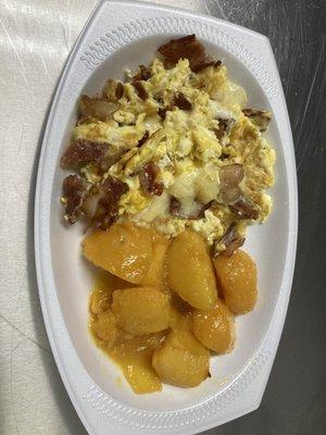 Scrambled eggs with bacon mixed in and Swiss cheese and house potatoes  Revuelto con tocino dentro y queso suizo y papas de la casa