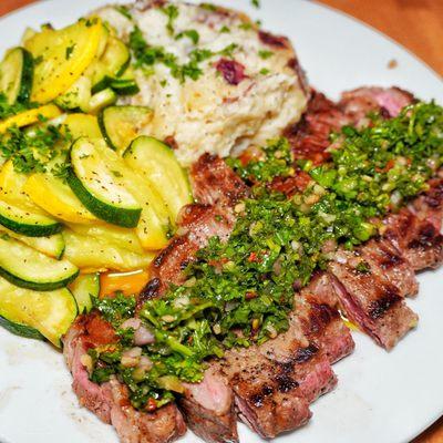 Steak with chimichurri and mashed potatoes and vegetables