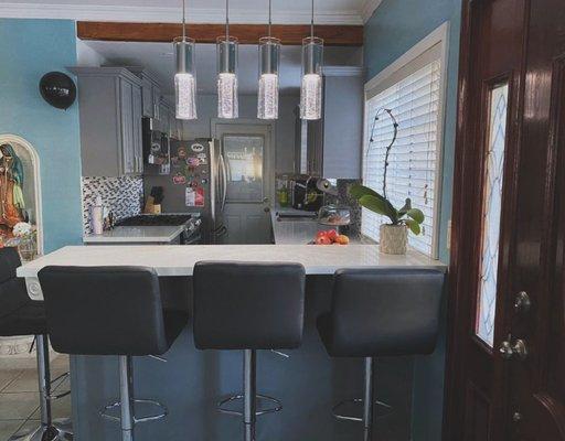 Elevate your kitchen game with a stunning backsplash and a chic raised bar peninsula!