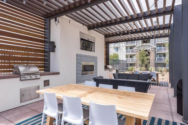 outdoor lounge area with a tv and fireplace