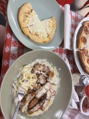 Chicken Alfredo with fried chicken and garlic bread.