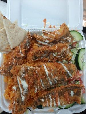 Fish over rice served with Salad and Pita Bread