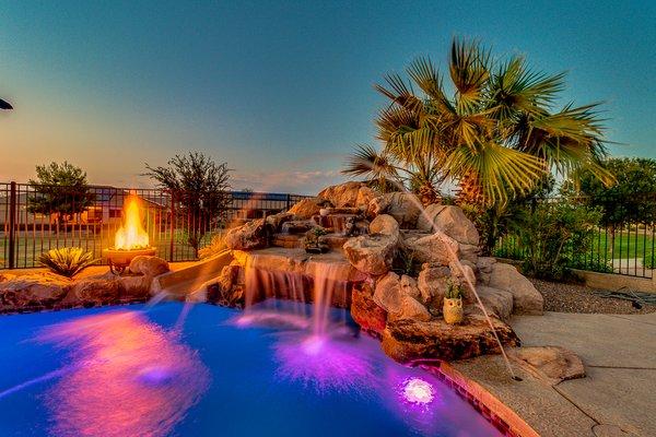 Pool with deck jets, grotto slide, and fire pit.