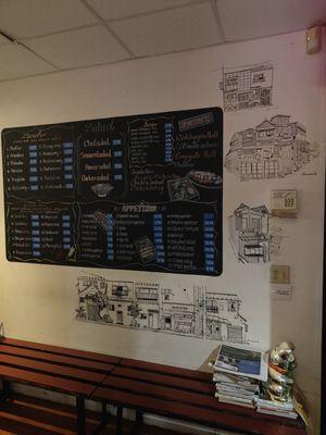 Menu board surrounded by incredible artwork created by Oom, the owner!