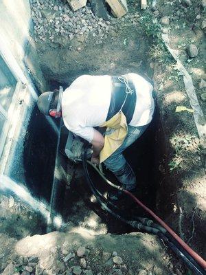 Hand sawing an egress window enlargement