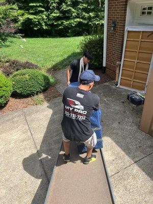 Unloading heavy furniture from one of our moving trucks in Chantilly, VA.