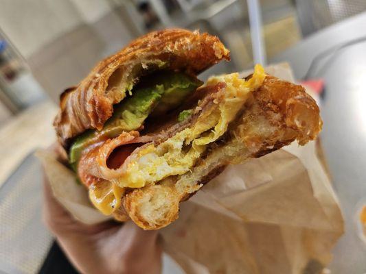 Ham egg and cheese croissant with avocado