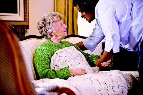 A Home Instead CAREGiver making sure her client is safe and comfortable.