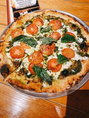 Our Pesto Pie topped with Thin-Sliced Tomato and Basil