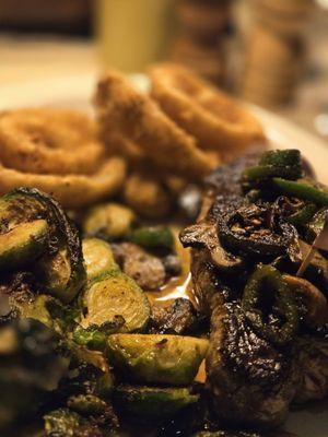 Bison filet with onion rings and Brussels and topped w/ sautéed mushroom and jalapeño