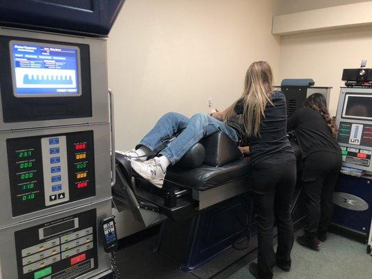 Lacy and Vanessa setting up a patient on the DRX9000 Spinal Decompression Technology